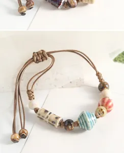 Detailed close-up view of handmade ceramic bead bracelet featuring adjustable braided cord.