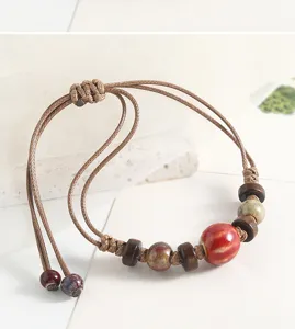 Close-up detail of vintage ceramic and wooden bead braided bracelet, ethnic handmade jewelry.