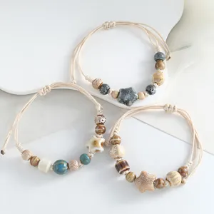 Handmade ceramic beaded bracelet with adjustable braided rope and unique star design.