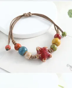 Handmade ceramic star bracelet with colorful glazed beads and woven rope, detailed view.