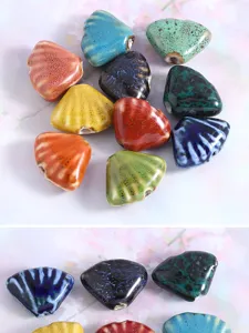 Close-up of colorful glazed ceramic scallop beads for DIY jewelry accessories detailing.