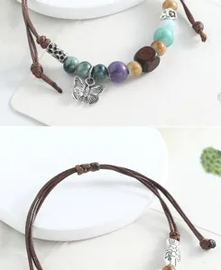 Detail shot of handmade braided rope bracelet with ceramic beads and cute butterfly charm.