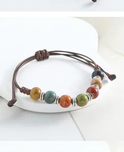 Handmade ceramic beaded bracelet close-up, colorful glazed beads with metal spacers detail.