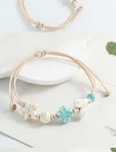 Delicate ceramic butterfly and star braided bracelet, minimalist handmade jewelry details view.