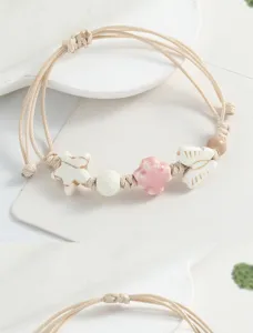 Close-up detail of the sweet literary woven bracelet featuring cute ceramic star and butterfly beads.