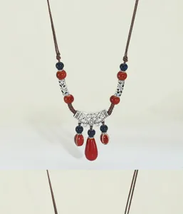 Bohemian long ceramic beaded necklace detail, retro drop pendant and silver carved metal elements.