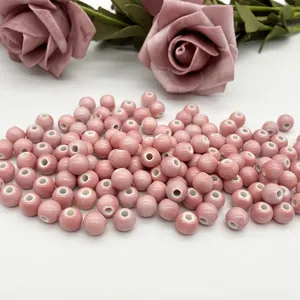 Close-up view of pink ceramic beads with center holes, ideal for custom DIY jewelry making.