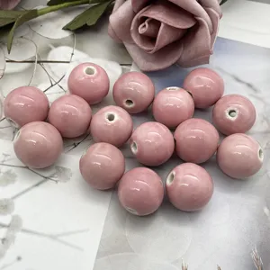Primo piano dettagliato che mostra perle di ceramica rosa lisce per accessori di gioielli.