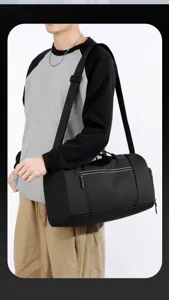 Vista dettagliata della borsa da viaggio nera multifunzionale portata sulla spalla del modello.