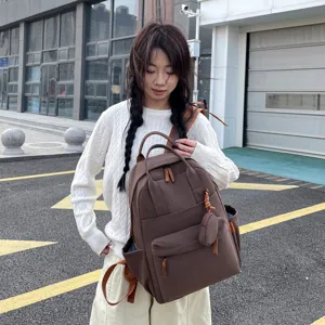 Detailaufnahme des stilvollen braunen Studentenrucksacks mit vielen Taschen und Münztasche.