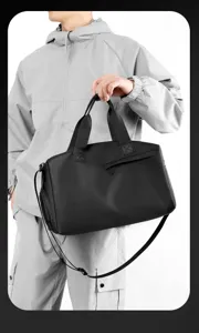 Detailaufnahme einer schwarzen wasserdichten Sport-Reisetasche mit praktischer Reißverschlusstasche.