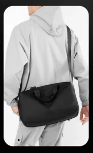 Detailansicht der schwarzen, wasserdichten Reisetasche mit Schultergurt und robustem Material.