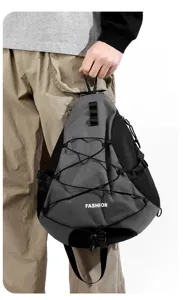 Close-up of grey nylon sling chest bag detail with bungee cord for outdoor hiking.