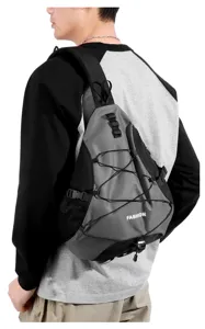 Detail view of grey nylon tactical sling backpack with mesh pocket and adjustable strap.