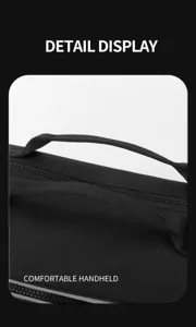 Primo piano della maniglia della borsa da viaggio nera, tessuto resistente, comoda impugnatura.