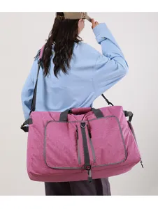 Gran bolsa de viaje rosa en detalle, con cremalleras resistentes y tela duradera de gran calidad.