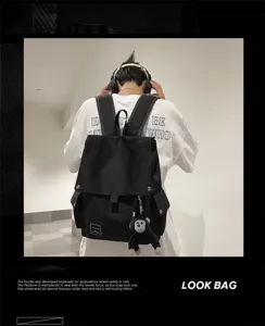 Black canvas casual school backpack with flap closure and cute monkey keychain detail.