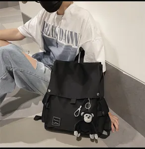 Casual canvas backpack for men and women, stylish school bag with flap and cute monkey pendant.