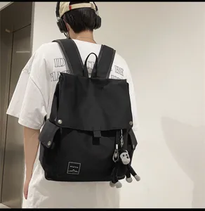 Casual canvas backpack for school students, minimalist flap daypack with monkey pendant.