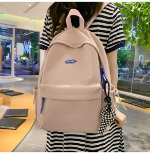 Detailaufnahme des pinken Studentenruckpacks mit Karomuster-Puppenanhänger und Fronttasche.