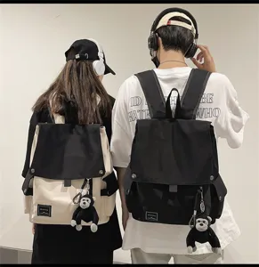 Casual canvas school backpack for students, featuring flap design and cute monkey pendant.
