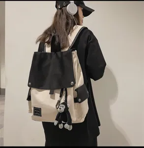 Casual canvas backpack with contrasting flap and cute monkey pendant for students daily use.
