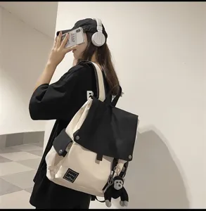Casual canvas school backpack with flap design and cute monkey pendant for students daily use.
