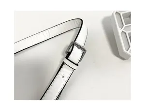 Close-up detail of white shoulder bag strap with silver metal buckle and black edge.