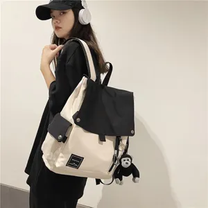 Casual canvas backpack for students, stylish color-block school bag with flap and cute monkey pendant.