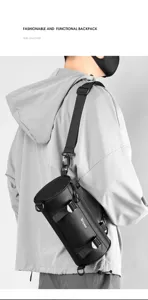 Detail shot of black cylinder sling bag, film-coated waterproof fabric, adjustable strap.