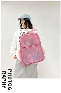 Gros plan détaillé du sac à dos en filet rose montrant le tissu respirant et sa poche.