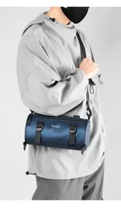 Detailed view of trendy men's blue cylinder crossbody bag, waterproof style and modern strap.