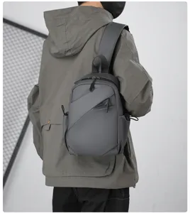 Detailed shot of trendy grey sling chest bag for men, stylish streetwear design and details.