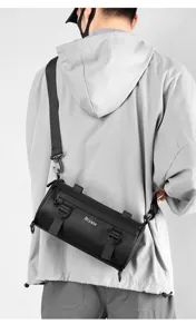 Black cylindrical crossbody sling bag detail with functional straps and waterproof finish.