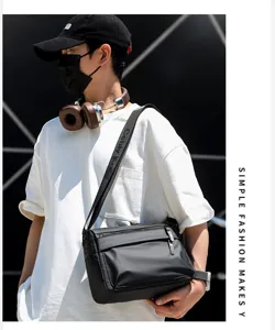 Detail shot of a stylish black messenger bag for men, featuring double zippers and a printed strap.