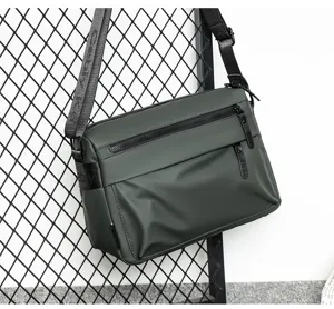 Men's waterproof messenger bag detail, dark green dual zipper crossbody bag for daily commute.