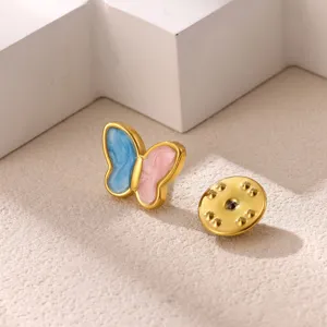 Enamel butterfly brooch detail showing blue and pink wings with gold-tone metal frame and backing.