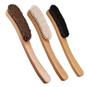Curved wooden handle shoe brush and clothes cleaning brush with three bristle color variants.