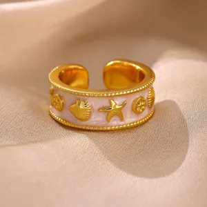 Vergoldeter offener Ring mit rosa Emaillierung und Muschel Meeresmotiven Detailaufnahme.