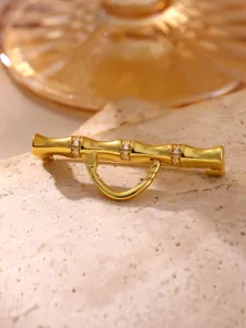 Vue rapprochée et détaillée d'un pendentif en bambou doré et d'une broche élégante polyva