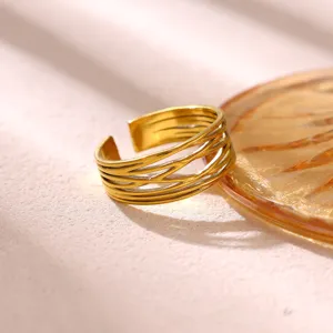 Gedetailleerde close-up van de brede geometrische vergulde roestvrijstalen open ring.