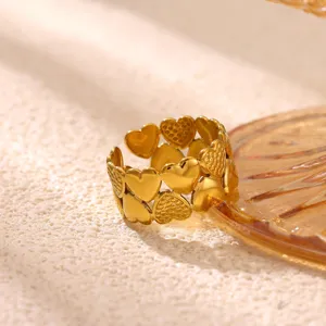 Gedetailleerd close-up van de vergulde roestvrijstalen ring met ineengstrengelde hartjes.
