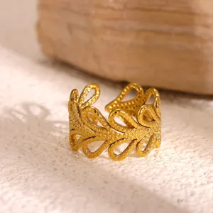 Detailweergave van de vergulde roestvrijstalen geometrische open ring met een hol ontworpen patroon.