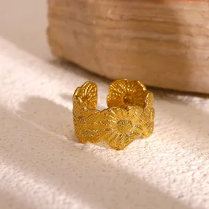 Gedetailleerde close-up van de elegante gouden roestvrijstalen bloem brede open ring.