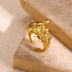 Gedetailleerd shot van de brede vergulde roestvrijstalen ring met onregelmatige lavatextuur.