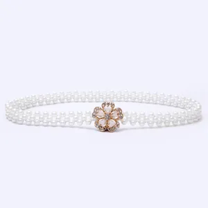 Close-up of the delicate gold rhinestone flower buckle and pearl beaded elastic belt.
