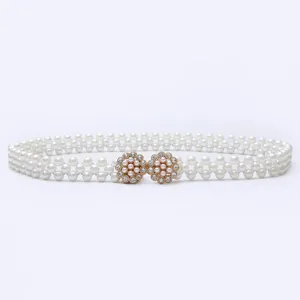 Detail view of double-row pearl elastic belt with sparkling rhinestone flower metal buckle.