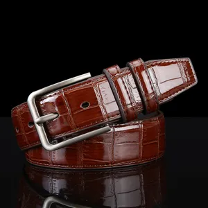 Cintura da uomo vintage in pelle coccodrillo con fibbia argentata dettaglio primo piano