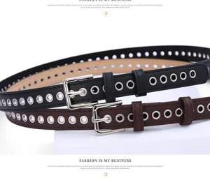 Close-up detail of women's metal grommet belt, featuring stylish eyelets and shiny buckle.