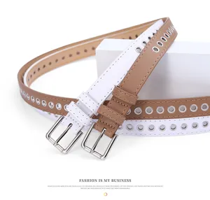 Detailed view of women's fashionable double-color leather belt with metal grommets.